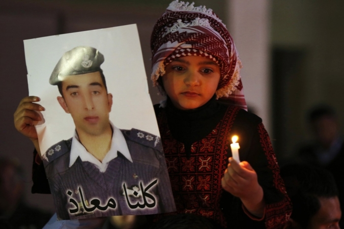 A Jordanian girl holds a poster of pilot Muath al-Kasaesbeh, who is being held captive by Islamic State militants, during a candlelit vigil in a show of solidarity with Japan, in front of the Japanese embassy in Amman, February 2, 2015. Jordanians on Monday staged a candlelit vigil outside the Japanese embassy in a tribute of solidarity with Japan and the family of Japanese journalist Kenji Goto, who was killed by the Islamic State, and to hold out hope for Jordanian pilot Kasaesbeh.