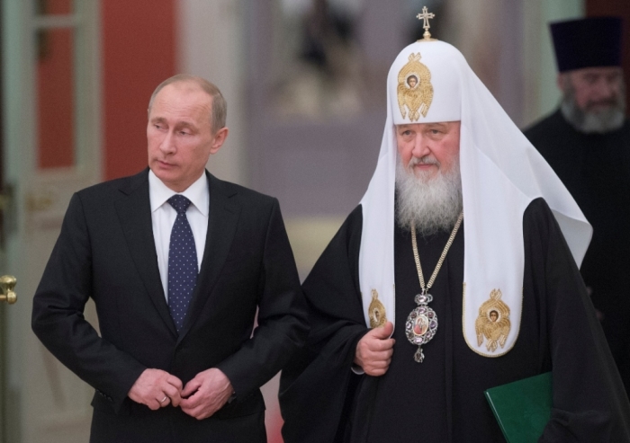 Russia’s President Vladimir Putin (L) and Patriarch of Moscow and All Russia Kirill arrive for the meeting with Russian Orthodox church bishops in Moscow, February 1, 2013. As troops loyal to Russian President Vladimir Putin were seizing control of Crimea, the head of the Russian Orthodox Church in Moscow deduced that an “internal political crisis” in Ukraine was threatening its territorial integrity.