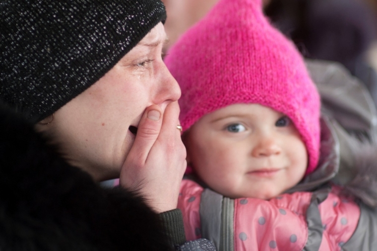 A woman cries as she holds a child, while on a bus waiting to flee the military conflict, in Debaltseve, Ukraine, February 3, 2015. Five Ukrainian soldiers have been killed and 27 wounded in fighting with pro-Russian separatists in Ukraine's eastern regions in the past 24 hours, Kiev military spokesman Andriy Lysenko said on Tuesday. Ukrainian military say fighting has been particularly intense around the town of Debaltseve, a major rail and road junction northeast of the city of Donetsk, which government troops are still holding.