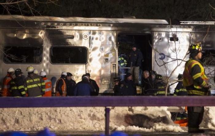Emergency workers stand in and around a burnt Metropolitan Transportation Authority (MTA) Metro North Railroad commuter train near the town of Valhalla, New York, February 3, 2015.