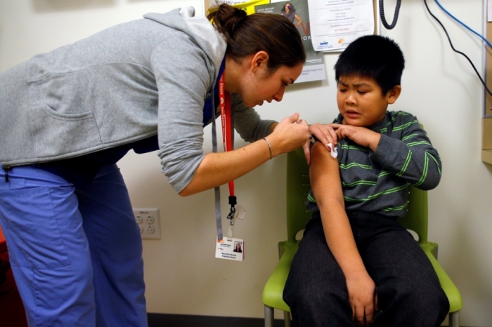 Nga Ngyen, 7, gets an influenza vaccine injection from nurse Maya Kahn-Woods during a flu shot clinic at Dorchester House, a health care clinic, in Boston, Massachusetts, January 12, 2013. Influenza has officially reached epidemic proportions in the United States, with 7.3 percent of deaths last week caused by pneumonia and the flu, the U.S. Centers for Disease Control and Prevention said on January 11.