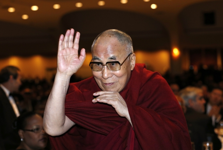 The Dalai Lama waves towards the head table, where U.S. President Barack Obama was seated, during the National Prayer Breakfast in Washington, February 5, 2015.