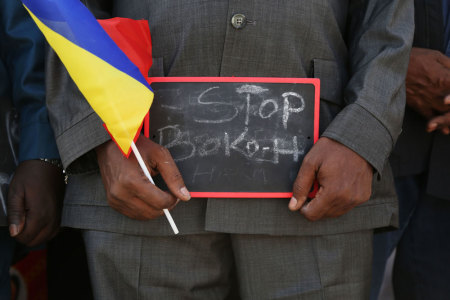 A man holds a sign that reads "Stop Boko Haram" at a rally to support Chadian troops heading to Cameroon to fight Boko Haram, in Ndjamena January 17, 2015.