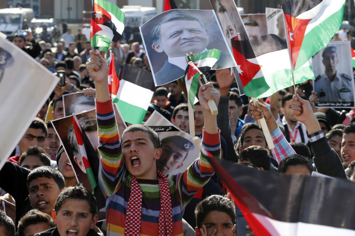 Protesters hold up pictures of Jordan's King Abdullah and pilot Muath al-Kasaesbeh as they chant slogans during a rally in Amman to show their loyalty to the King and against the Islamic State, February 5, 2015.