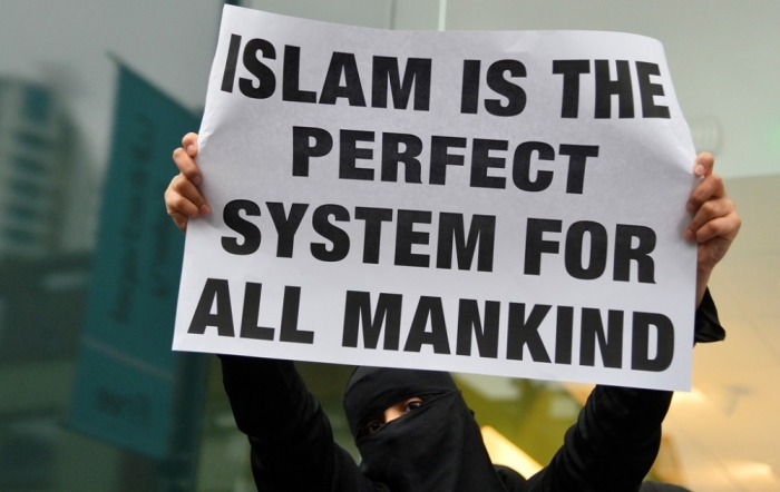 A woman holds a placard during a march and rally in east London, December 13, 2013. They were participating in a rally organized by British Islamist Anjem Choudary condemning use of alcohol and promoting Shariah law.