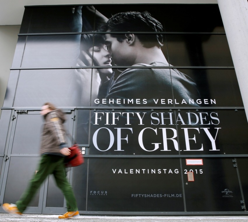 A pedestrian walks past an advertising placard for the movie "Fifty Shades of Grey," which will be screened at the upcomming 65th Berlinale International Film Festival in Berlin, Germany, February 4, 2015. The February 5-15 Berlinale kicks off the European festival season.