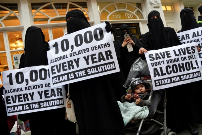 Women hold placards during a march and rally in east London, December 13, 2013. They were participating in a rally organized by British Islamist Anjem Choudary condemning use of alcohol and promoting Shariah law.