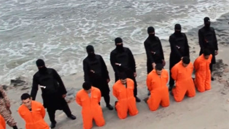 Men in orange jumpsuits purported to be Egyptian Christians held captive by the Islamic State (IS) kneel in front of armed men along a beach said to be near Tripoli, in this still image from an undated video made available on social media on February 15, 2015. Islamic State released the video on Sunday purporting to show the beheading of 21 Egyptian Christians kidnapped in Libya. In the video, militants in black marched the captives to a beach that the group said was near Tripoli. They were forced down onto their knees, then beheaded. Egypt's state news agency MENA quoted the spokesman for the Coptic Church as confirming that 21 Egyptian Christians believed to be held by Islamic State were dead.