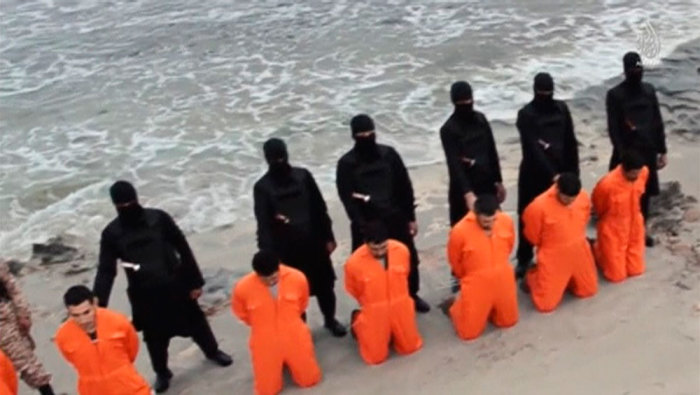 Men in orange jumpsuits purported to be Egyptian Christians held captive by the Islamic State (IS) kneel in front of armed men along a beach said to be near Tripoli, in this still image from an undated video made available on social media on February 15, 2015. Islamic State released the video on Sunday purporting to show the beheading of 21 Egyptian Christians kidnapped in Libya. In the video, militants in black marched the captives to a beach that the group said was near Tripoli. They were forced down onto their knees, then beheaded. Egypt's state news agency MENA quoted the spokesman for the Coptic Church as confirming that 21 Egyptian Christians believed to be held by Islamic State were dead.