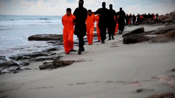 Men in orange jumpsuits purported to be Egyptian Christians held captive by the Islamic State are marched by armed men along a beach said to be near Tripoli, in this still image from an undated video made available on social media on February 15, 2015. Islamic State released the video on Sunday purporting to show the beheading of 21 Egyptian Christians kidnapped in Libya. In the video, militants in black marched the captives to a beach that the group said was near Tripoli. They were forced down onto their knees, then beheaded. Egypt's state news agency MENA quoted the spokesman for the Coptic Church as confirming that 21 Egyptian Christians believed to be held by Islamic State were dead.