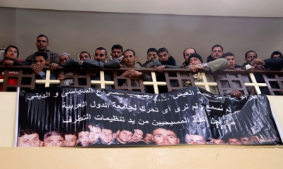 Neighbours and friends of the relatives of Egyptian Coptic men killed in Libya attend mass at a church, as a banner with pictures of the men who were men is displayed on the church wall, in El-Our village, in Minya governorate, south of Cairo, February 16, 2015. Egyptian jets bombed Islamic State targets in Libya on Monday, a day after the group there released a video showing the beheading of 21 Egyptian Christians, drawing Cairo directly into the conflict across its border.