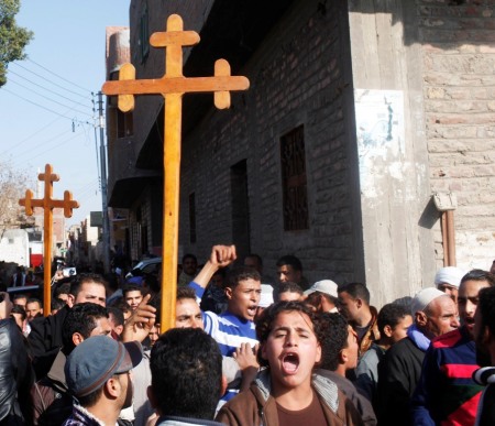 Relatives and neighbours of Egyptian Coptic men killed in Libya chant pro-army slogans during a protest while carrying crosses in al-Our village, in Minya governorate, south of Cairo, February 16, 2015. Thousands of traumatized mourners gathered on Monday at the Coptic church in al-Our village south of Cairo, struggling to come to terms with the fate of compatriots who paid a gruesome price for simply seeking work in Libya. Thirteen of 21 Egyptians beheaded by Islamic State came from the impoverished dirt lanes of al-Our, violence that prompted the Egyptian military to launch an air strike on Islamic State militant targets in Libya.
