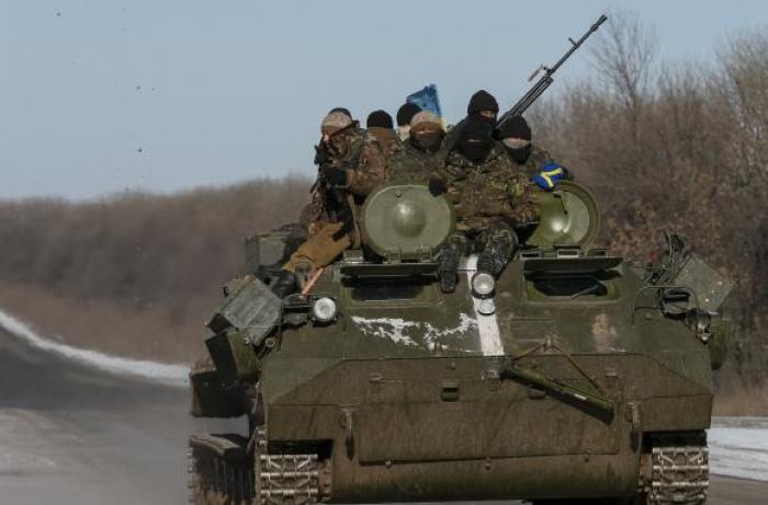 Members of the Ukrainian armed forces ride on a military vehicle near Debaltseve, eastern Ukraine, February 17, 2015.