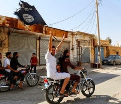 Youth on motorbike holds up ISIS flag, (FILE).