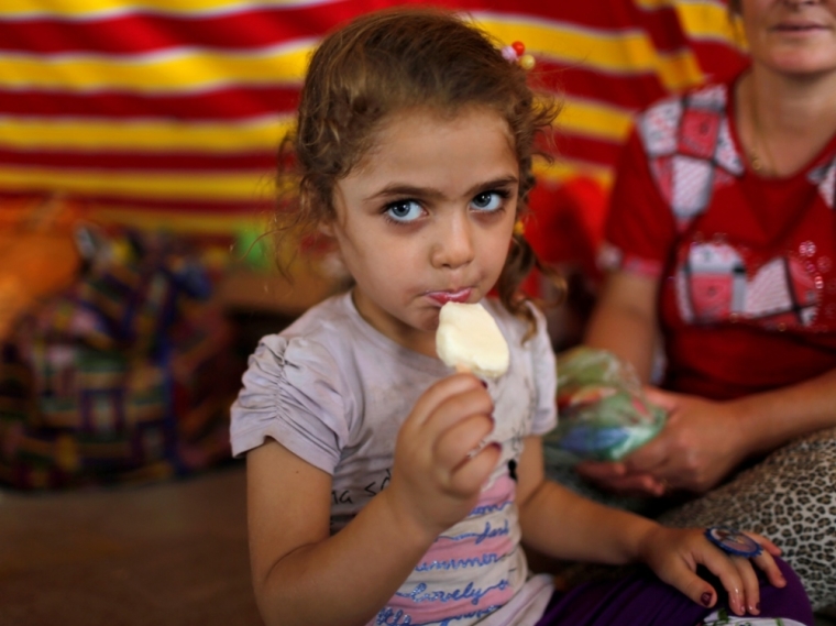 A displaced Iraqi Christian girl who fled from Islamic State militants in Mosul, eats an ice-cream at a mall still under construction, which is now used as a refugee camp in Erbil, September 6, 2014.