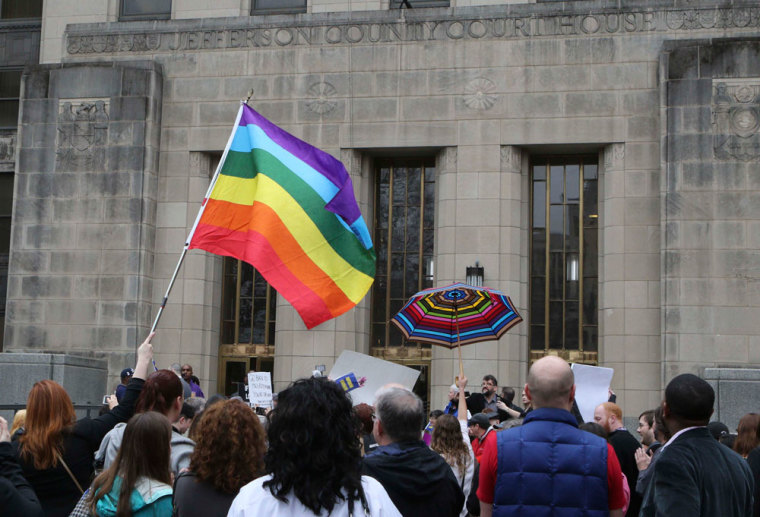 Supporters of same-sex marriage hold a rainbow flag and a rainbow umbrella outside Jefferson County Courthouse in Birmingham, Alabama February 9, 2015. Same-sex couples began marrying in Alabama on Monday despite an attempt by the conservative chief justice of the state's Supreme Court to block judges from issuing marriages licenses to gay men and women in open defiance of a January federal court ruling.