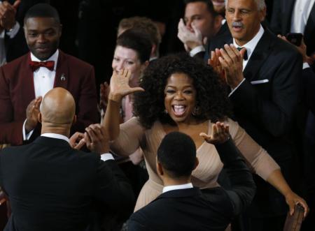 Ophra Winfrey (C) congratulates John Legend (bottom R) and Common (bottom L), as actor David Oyelowo (top L) looks on, after "Glory" from the film "Selma" won the Oscar for best original song during the 87th Academy Awards in Hollywood, California February 22, 2015.