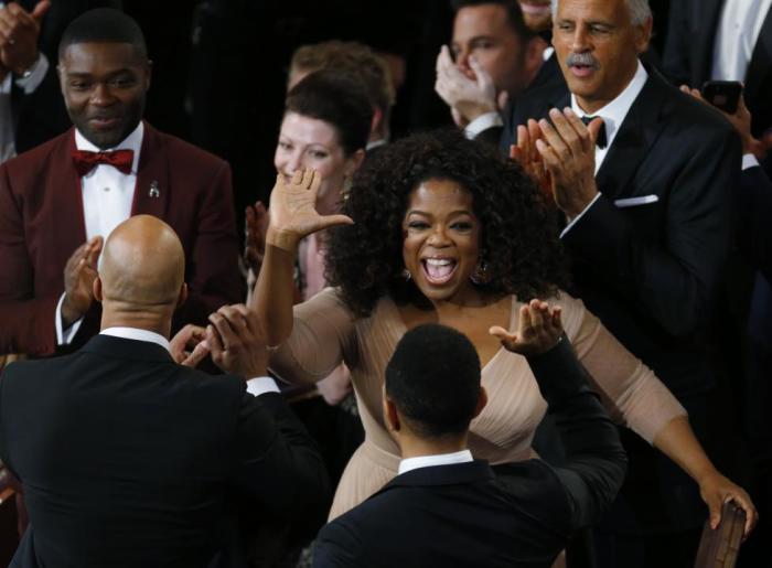 Ophra Winfrey (C) congratulates John Legend (bottom R) and Common (bottom L), as actor David Oyelowo (top L) looks on, after 'Glory' from the film 'Selma' won the Oscar for best original song during the 87th Academy Awards in Hollywood, California February 22, 2015.