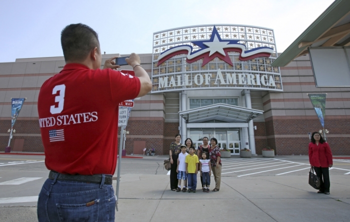 Visitors pose for a family photograph in front of an entrance to the Mall of America in Bloomington, Minnesota, July 2, 2013.