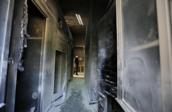 A man looks at damage at a Greek Orthodox seminary in Jerusalem, February 26, 2015. A fire damaged a Greek Orthodox seminary in Jerusalem on Thursday and anti-Christian graffiti was found at the scene in what Israeli police said could be a hate crime.