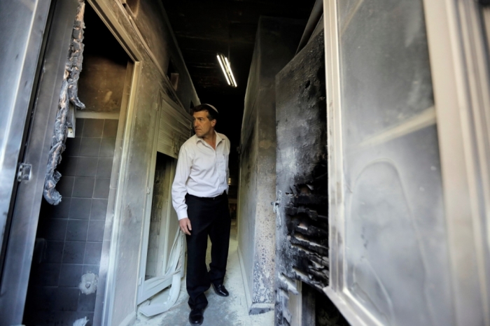 An Israeli man looks at damage at a Greek Orthodox seminary in Jerusalem, February 26, 2015. A fire damaged a Greek Orthodox seminary in Jerusalem on Thursday and anti-Christian graffiti was found at the scene in what Israeli police said could be a hate crime.