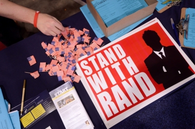 A guest reaches for a flag pin at the Senator Rand Paul, R-Ky., booth at the Conservative Political Action Conference in National Harbor, Maryland, February 28, 2015. CPAC closes after three days where thousands of conservative activists, Republicans and Tea Party Patriots gathered to hear politicians, presidential hopefuls, and business leaders speak, lobby and network for a conservative agenda, ahead of the presidential election in 2016.