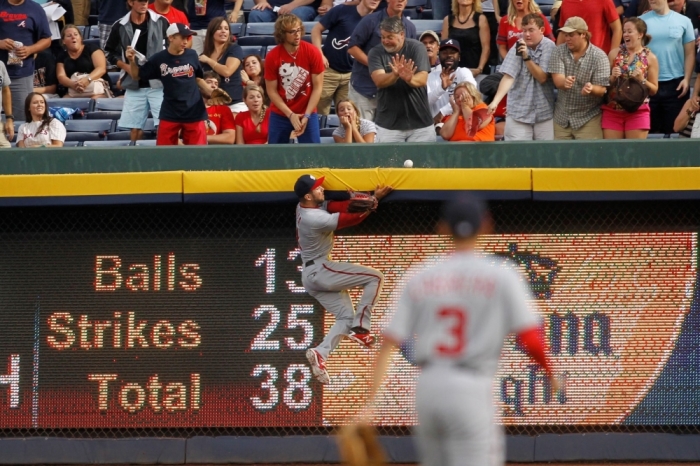 Former Washington Nationals right fielder Steven Souza (21) collides with the outfield wall as he attempts to catch a home run in Atlanta on Aug. 8, 2014.