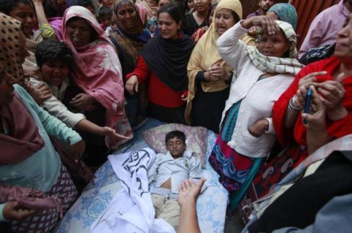 People mourn as they surround the body of their relative who was killed in a suicide attack on a church in Lahore March 15, 2015.