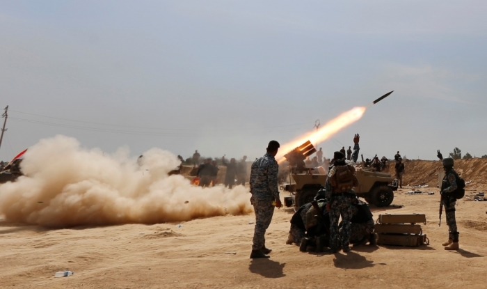 Members of the Iraqi security forces and Shi'ite fighters fire a rocket, during clashes with Islamic State militants in the town of Tal Ksaiba, near the town of al-Alam, March 7, 2015. Iraqi security forces and Shi'ite militia fighters struggled to advance on Saturday into the two towns of al-Alam and al-Dour near Tikrit, their progress slowed by fierce defence from Islamic State militants.