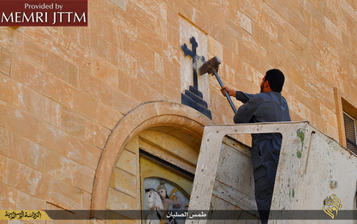 ISIS published a collection of images showing an array of acts of vandalism perpetrated against churches in Ninawa, Iraq, on March 16, 2015. The images show ISIS men engaged in the destruction of various Christian symbols, which ISIS perceives as being polytheistic and idolatrous. The men remove crosses from atop churches and replace them with the black ISIS banner, destroy crosses at other locations such as atop doorways and gravestones, and destroy and remove icons and statues inside and outside churches.