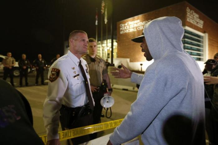 A protester talks with a police officer in front of the Ferguson Police Department in Ferguson, Missouri, March 12.