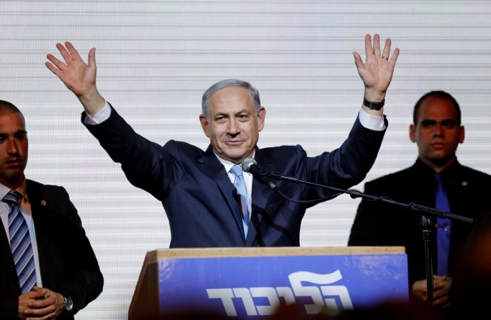 Israeli Prime Minister Benjamin Netanyahu waves to supporters at the party headquarters in Tel Aviv, March 18, 2015. Netanyahu claimed victory in Israel's election after exit polls showed he had erased his center-left rivals' lead with a hard rightward shift in which he abandoned a commitment to negotiate a Palestinian state.