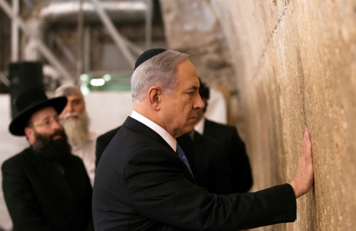 Israel's Prime Minister Benjamin Netanyahu touches the stones of the Western Wall, Judaism's holiest prayer site, in Jerusalem's Old City, March 18, 2015. Netanyahu won a come-from-behind victory in Israel's election after tacking hard to the right in the final days of campaigning, including abandoning a commitment to negotiate a Palestinian state.