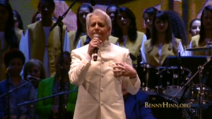 Televangelist Benny Hinn, ministering recently in Brazil, places a hand over his heart.
