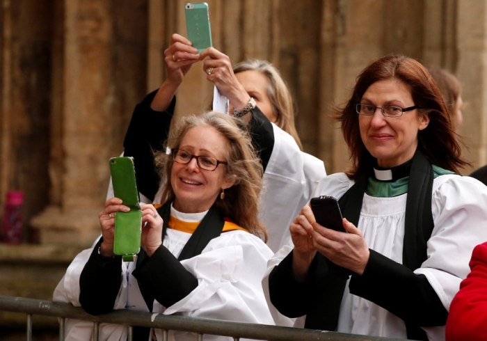 Woman clergy take photographs of the first female bishop in the Church of England Libby Lane following her consecration service at York Minster in York, northern England, January 26, 2015.