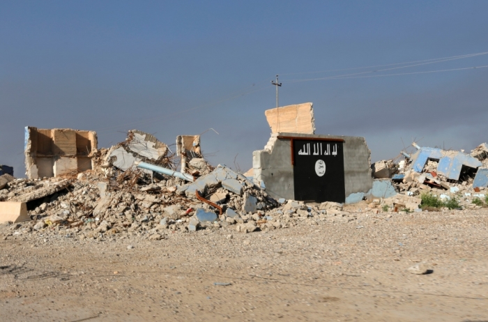 A destroyed building with a wall painted with the black flag commonly used by Islamic State militants, is seen in the town of al-Alam, March 10, 2015. Iraqi troops and militias drove Islamic State insurgents out of al-Alam on Tuesday, clearing a final hurdle before a planned assault on Saddam Hussein's home city of Tikrit in their biggest offensive yet against the ultra-radical group.