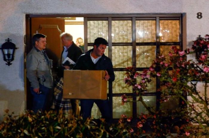German police officers carry boxes out of a house believed to belong to the parents of Andreas Lubitz on March 26, 2015.