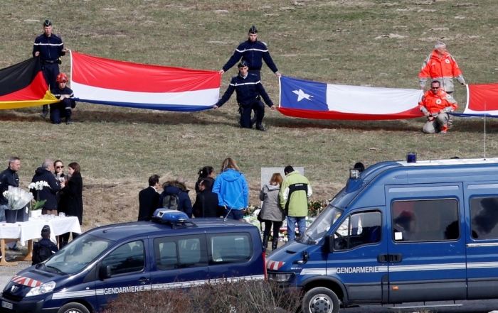 Flags representing some of the nationalities of the victims are seen as family members and relatives gather at the momorial, near the crash site of a Germanwings Airbus A320, in Le Vernet, in French Alps, March 29, 2015. The co-pilot suspected of deliberately crashing a passenger plane in the French Alps told his girlfriend he was in psychiatric treatment, and that he was planning a spectacular gesture that everyone would remember, the German daily Bild reported on Saturday.