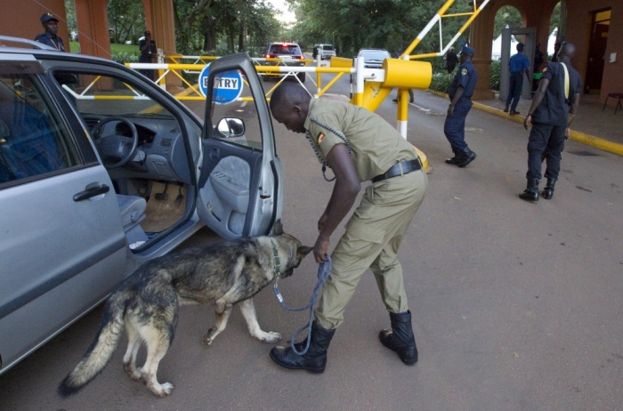 A security personnel guides a sniffer dog as he carries out security checks at the entrance to a hotel in Kampala March 26, 2015. Uganda has bolstered security at key locations because of fears Somalia's Islamist al Shabaab insurgents are planning an attack following warnings from the United States, officials said.