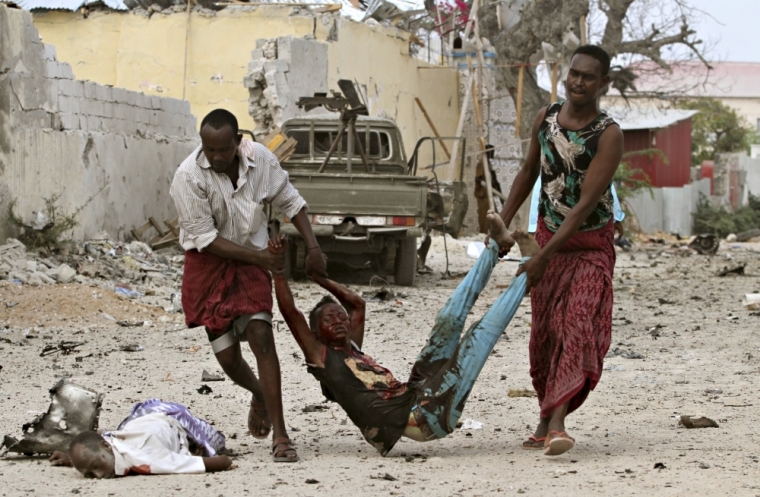 Residents evacuate an injured boy after Islamist group al Shabaab attacked Maka Al-Mukarama hotel in Mogadishu, March 27, 2015. Islamist militants blasted their way into a popular hotel in the Somali capital Mogadishu on Friday, killing at least seven people and trapping government officials inside, police and witnesses said.