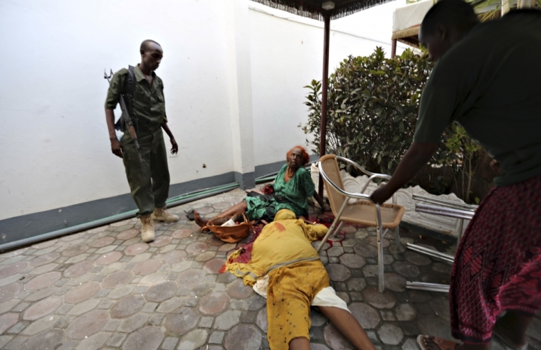 Somali policemen secure injured women as Islamist group al Shabaab attacked Maka Al-Mukarama hotel in Mogadishu, March 27, 2015. Islamist militants blasted their way into a popular hotel in the Somali capital Mogadishu on Friday, killing at least seven people and trapping government officials inside, police and witnesses said. REUTERS/Feisal Omar
