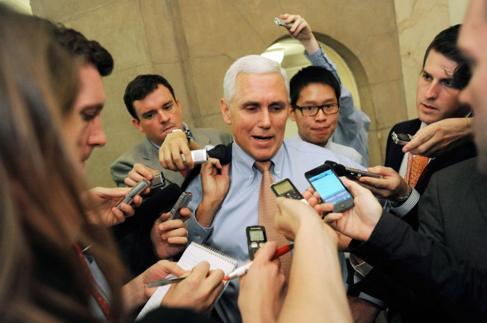 U.S. Representative Mike Pence (R-IN) (C) talks with reporters as he departs a meeting about debt ceiling legislation with fellow Republicans at the U.S. Capitol in Washington, July 28, 2011.