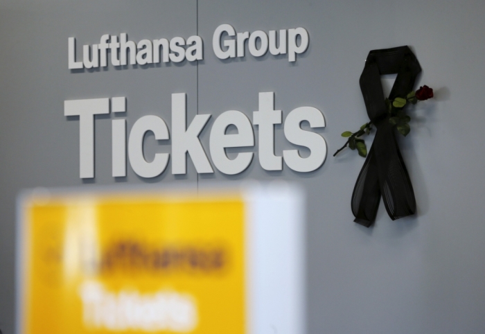 The logo of Germanwings, a member of the Lufthansa Group, is seen next to a black ribbon and a flower commemorating the victims of Germanwings flight 4U9525, at a ticket counter of two airlines in Duesseldorf's airport April 2, 2015. The second black box, the so-called data recorder of the Airbus A320 was discovered on Wednesday in the mountains where the Germanwings aircraft crashed last week. The co-pilot suspected of deliberately crashing the aircraft killing all150 people who were on board told the Lufthansa flight training school about a previous period of depression, Lufthansa said on March 31, 2015.