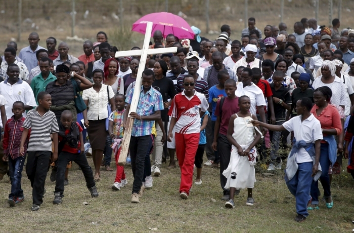 A Christian man carries a cross during Good Friday procession outside Nairobi, Kenya, April 3, 2015.