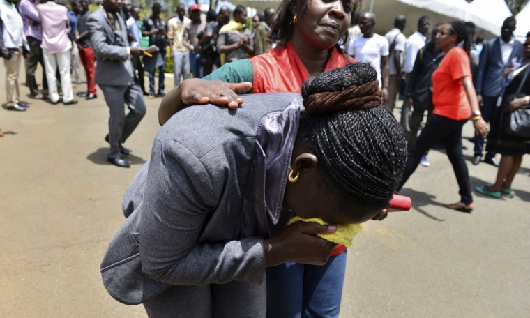 A relative is assisted by Red Cross staff as bodies of the students killed in Thursday's attack by gunmen, arrive at the Chiromo Mortuary in Nairobi, April 3, 2015. The death toll in an assault by Somali militants on a Kenyan university is likely to climb above 147, a government source and media said on Friday, as anger grew among local residents over what they say was a government failure to prevent bloodshed. Strapped with explosives, masked al Shabaab gunmen stormed the Garissa University College campus in a pre-dawn rampage on Thursday.
