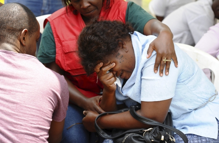 A relative is assisted by Red Cross staff as bodies of the students killed in Thursday's attack by gunmen, arrive at the Chiromo Mortuary in Nairobi, April 3, 2015. The death toll in an assault by Somali militants on a Kenyan university is likely to climb above 147, a government source and media said on Friday, as anger grew among local residents over what they say was a government failure to prevent bloodshed. Strapped with explosives, masked al Shabaab gunmen stormed the Garissa University College campus in a pre-dawn rampage on Thursday.