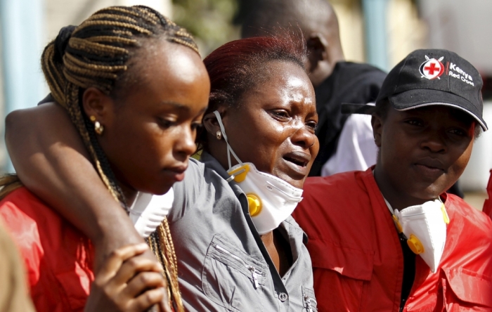 A relative (C) is assisted by Kenya Red Cross staff as she reacts at the Chiromo Mortuary, where bodies of students killed in Thursday's attack by gunmen are preserved, in Nairobi April 6, 2015.