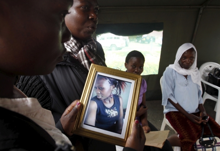 A relative carries a picture of a student killed in Thursday's attack by gunmen, at the Chiromo Mortuary in Kenya's capital Nairobi, April 6, 2015. The Kenyan air force has destroyed two al-Shabaab camps in Somalia, it said on Monday, in the first major military response since the Islamist group massacred students at a Kenyan university last week.