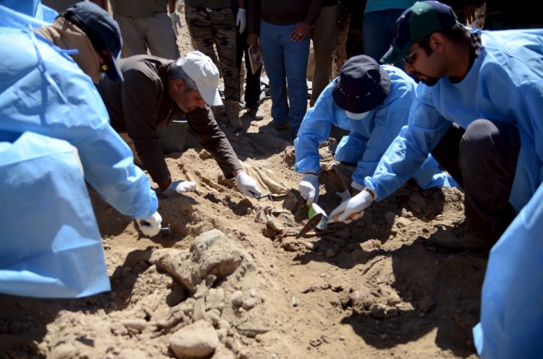 Members from the Iraqi forensic team search to extract the remains of the bodies belonging to Shiite soldiers from Camp Speicher who have been killed by Islamic State militants at a mass grave in the presidential compound of the former Iraqi president Saddam Hussein in Tikrit, April 6, 2015. Iraqi forensic teams began on Monday excavating 12 suspected mass grave sites thought to hold the corpses of as many as 1,700 soldiers massacred last summer by Islamic State militants as they swept across northern Iraq.