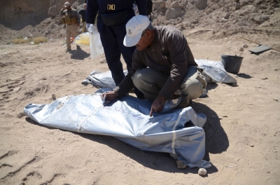 A member from the Iraqi forensic team writes on the body bag of remains belonging to Shiite soldiers from Camp Speicher who have been killed by Islamic State militants at a mass grave in the presidential compound of the former Iraqi president Saddam Hussein in Tikrit, April 6, 2015. Iraqi forensic teams began on Monday excavating 12 suspected mass grave sites thought to hold the corpses of as many as 1,700 soldiers massacred last summer by Islamic State militants as they swept across northern Iraq.